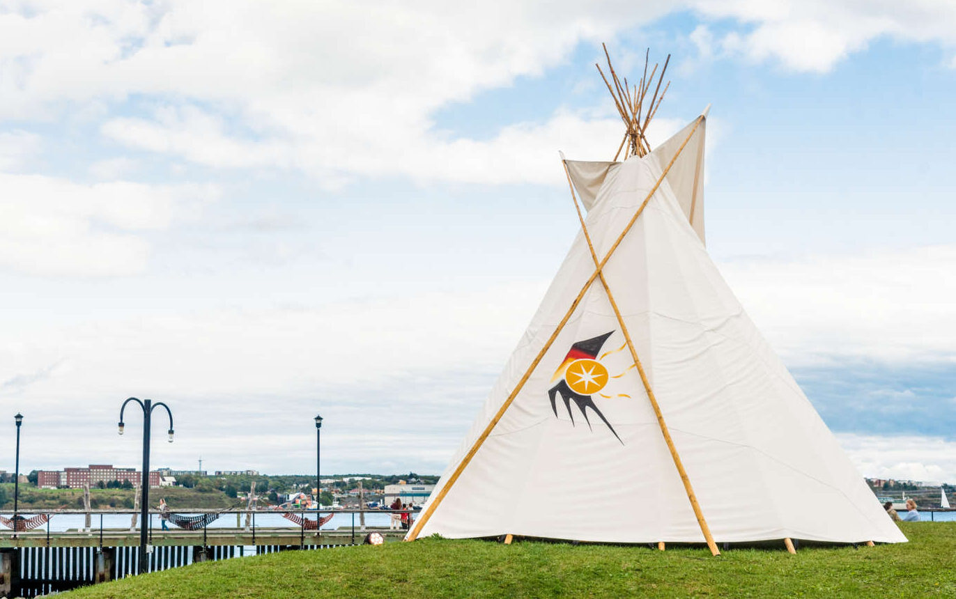 Wigwam on grassy area on city waterfront