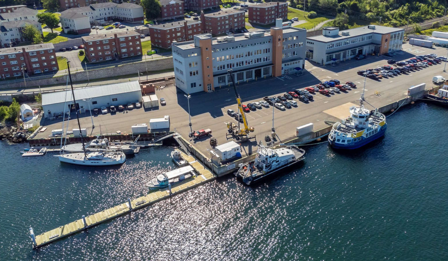 Aerial photo of waterfront building complex and boats docked