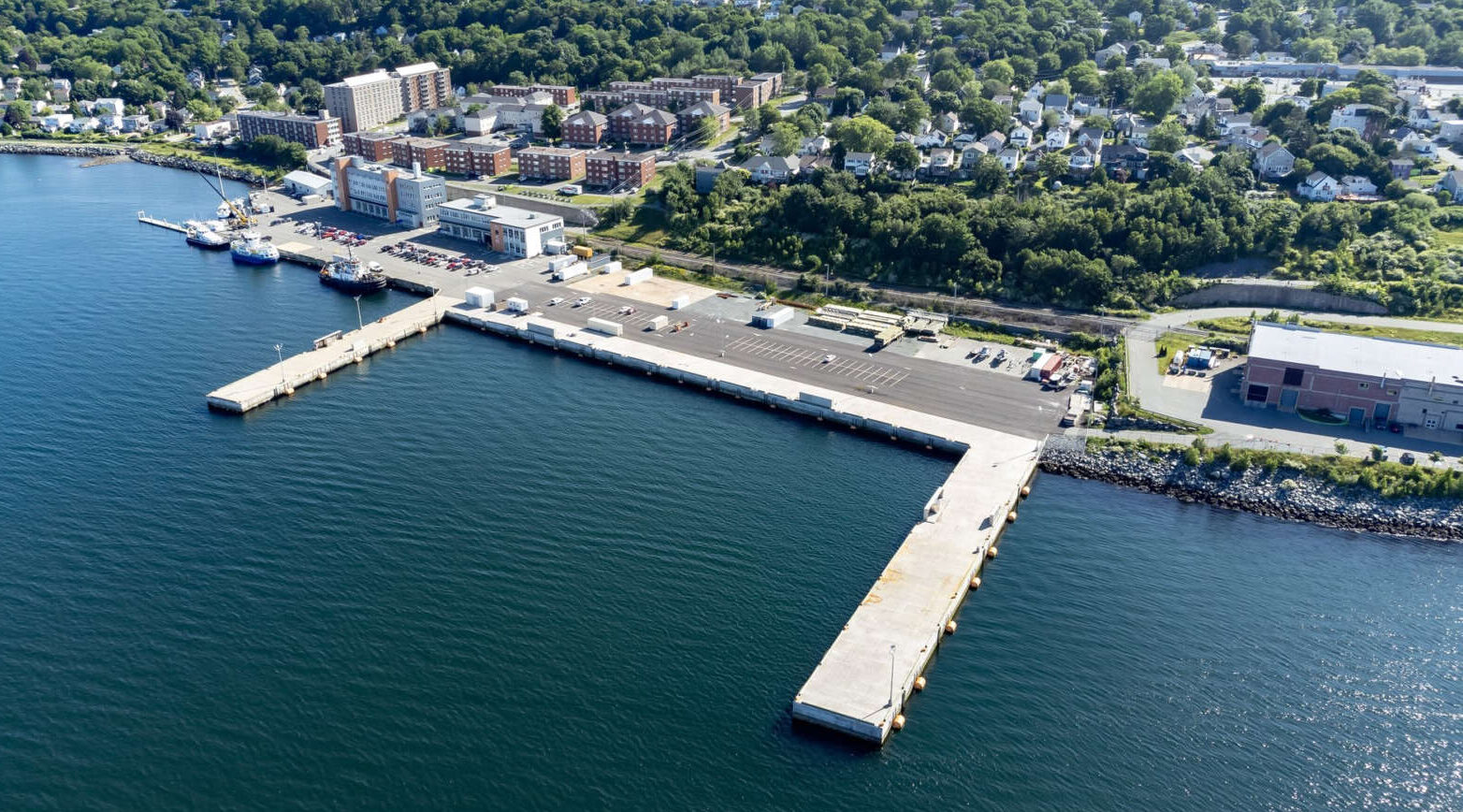 Aerial photo of waterfront building complex and wharfs leading out to harbour