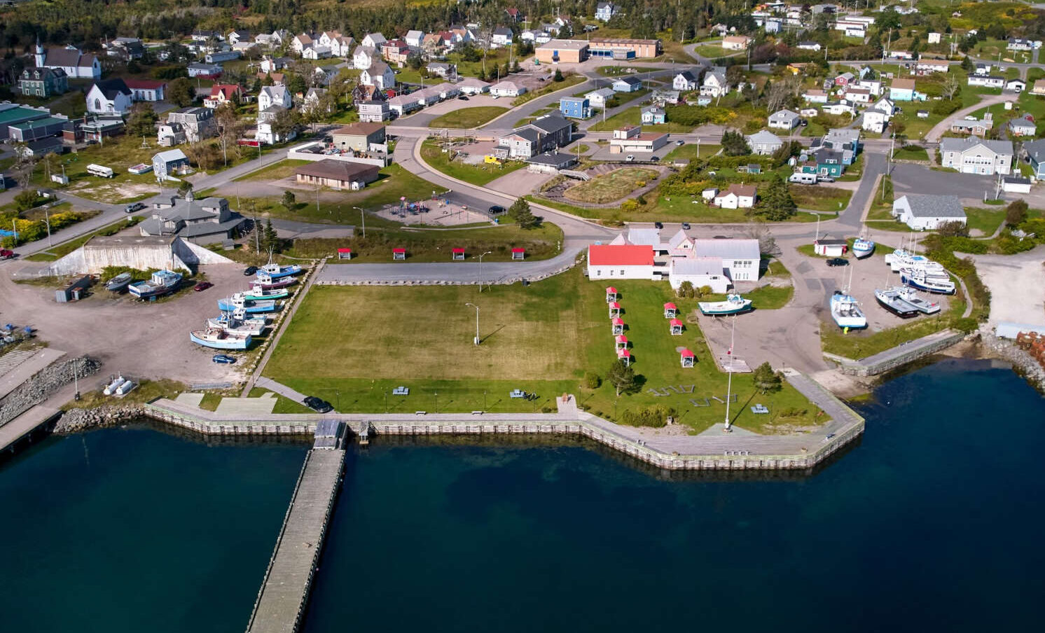 Aerial photo of town and waterfront with wharf and large grassy area